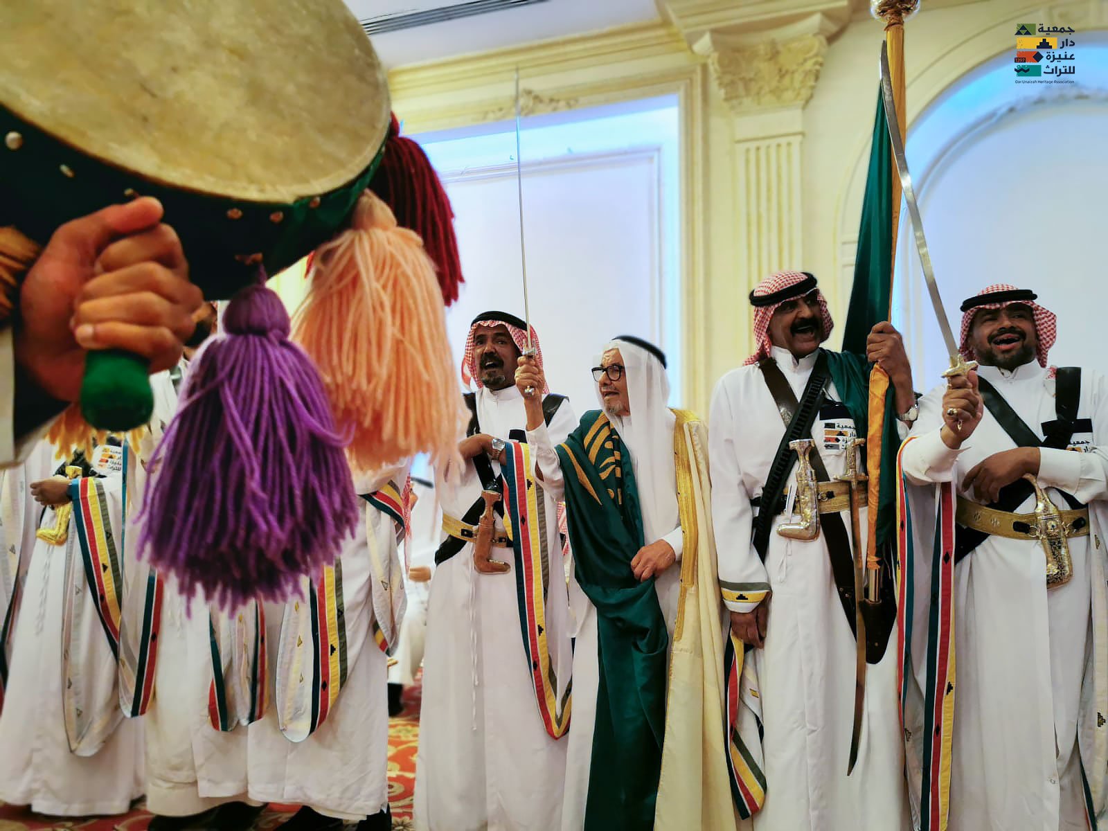 فرقة دار عنيزة للتراث الشعبي بالزي التقليدي مع السيوف والدفوف